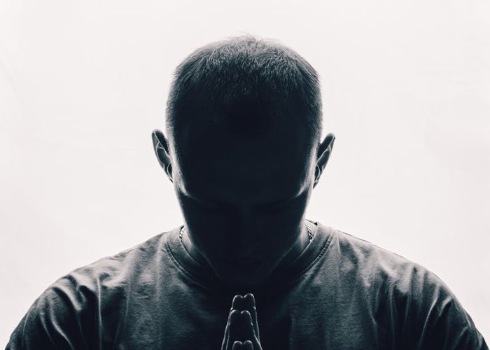 Silhouette of a man in a power stance against a bright window, symbolizing focus.